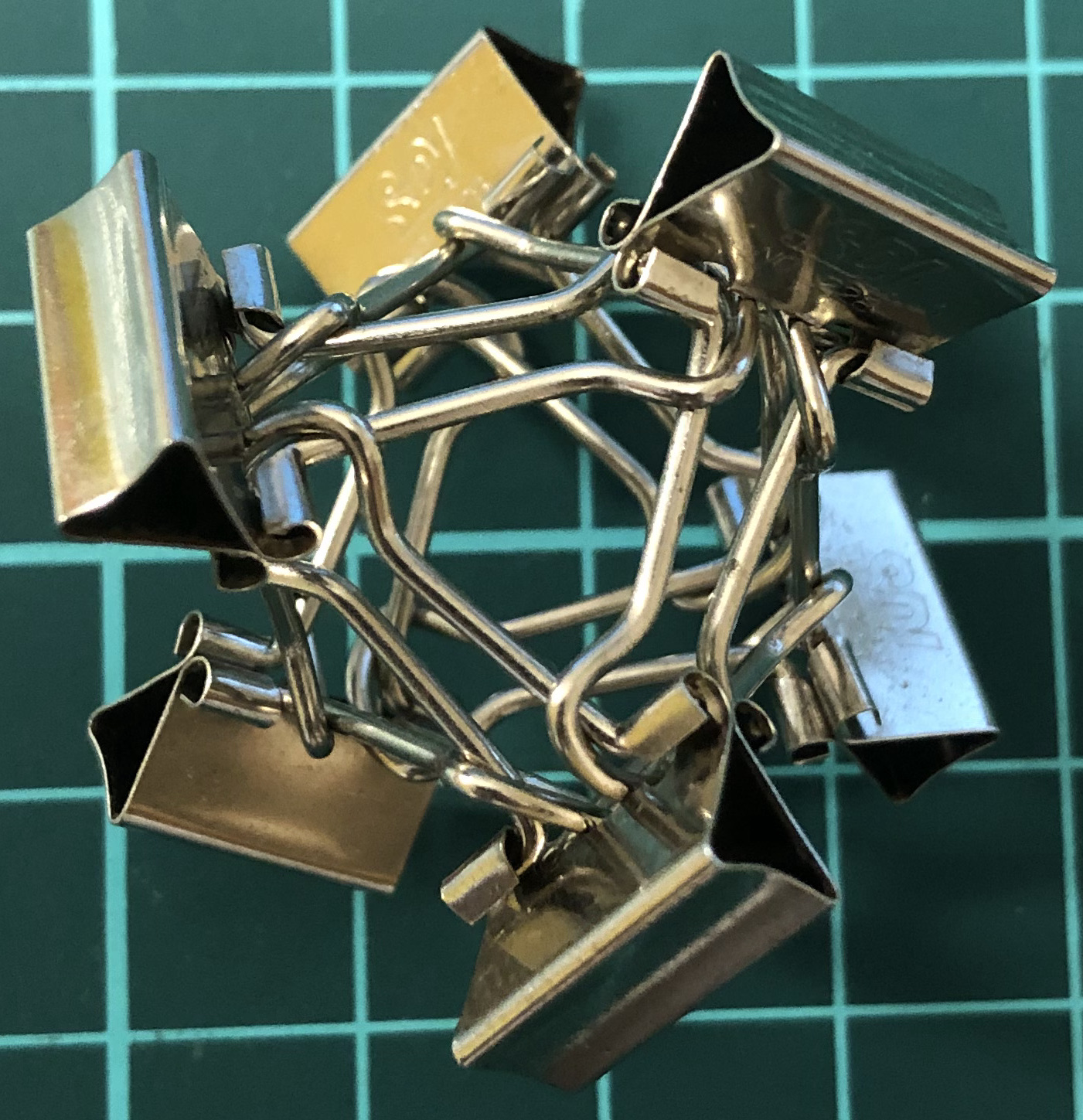 6 binder clips whose bodies stand on the octahedron formed by handles