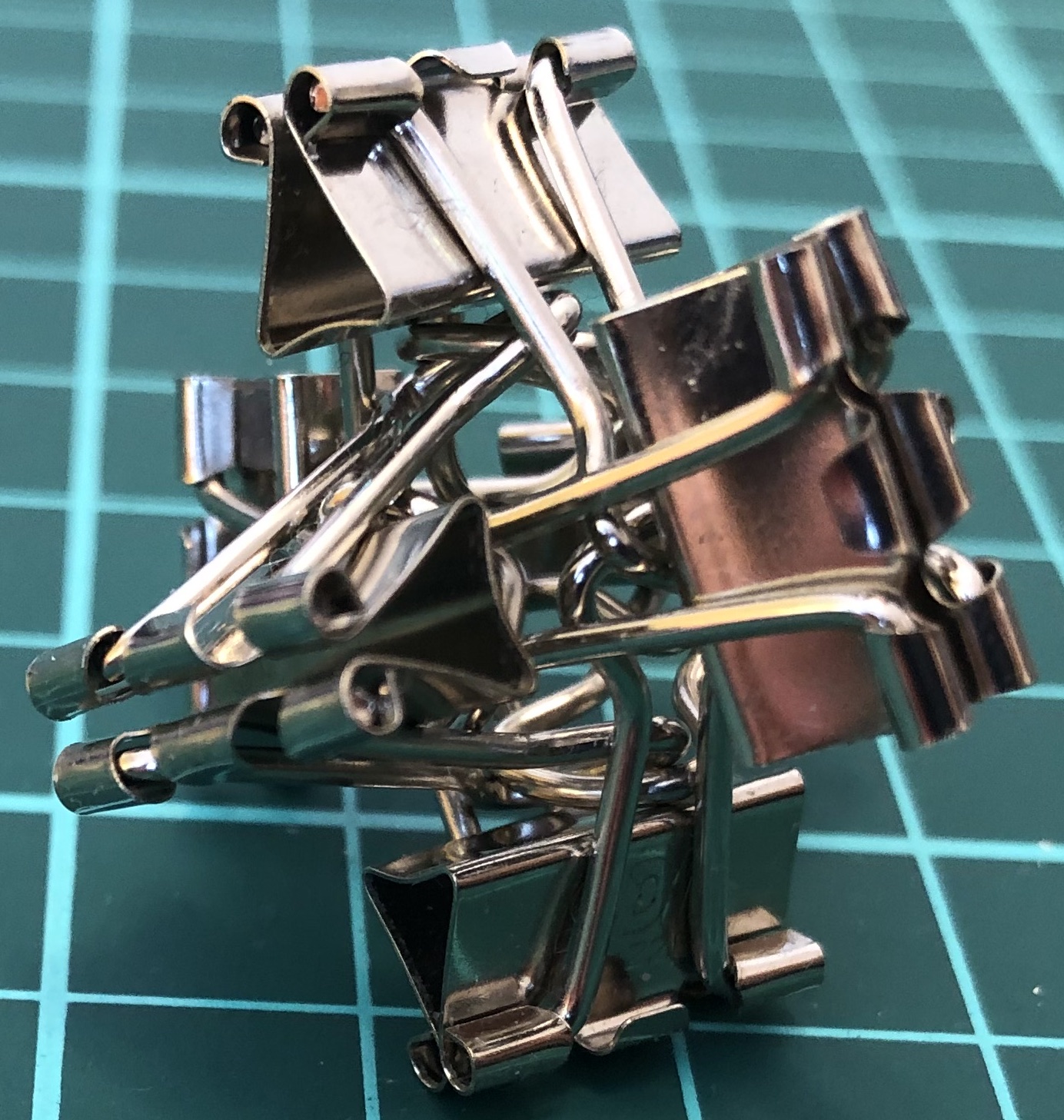 6 binder clips with mouths pointing outward